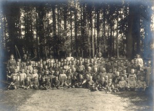 De weeskinderen die tijdens de Eerste Wereldoorlog op het domein van kasteel ter Gaever werden opgevangen, poseren met speeltuigen in het park. Archief de Bergeyck, collectie John Buyse